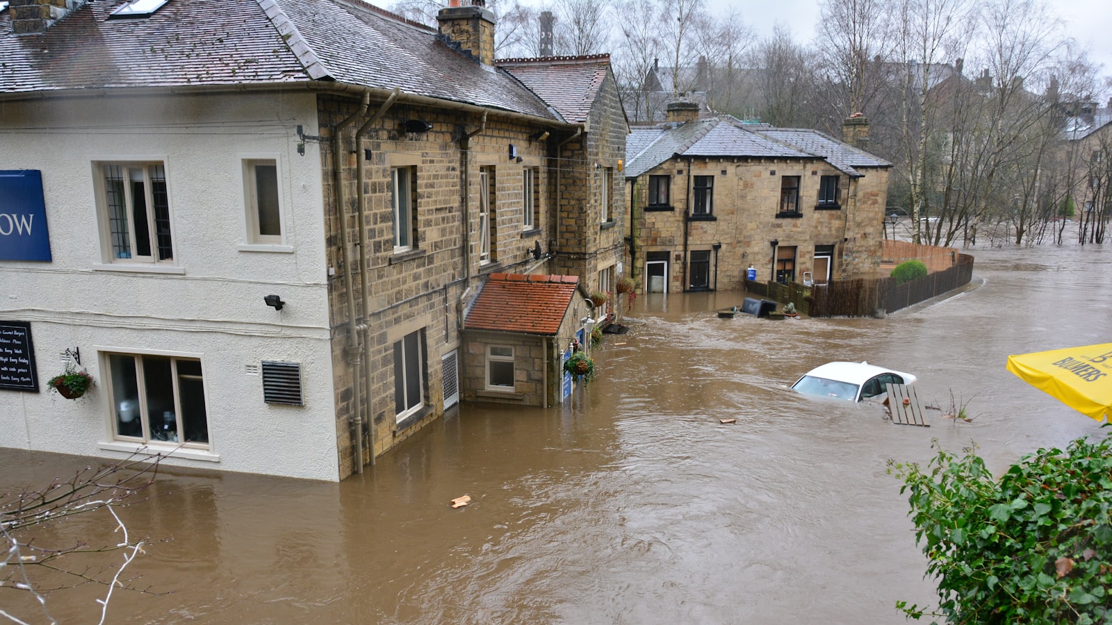 Überflutete Straße mit Wohnhäusern nach Starkregen und Hochwasser
