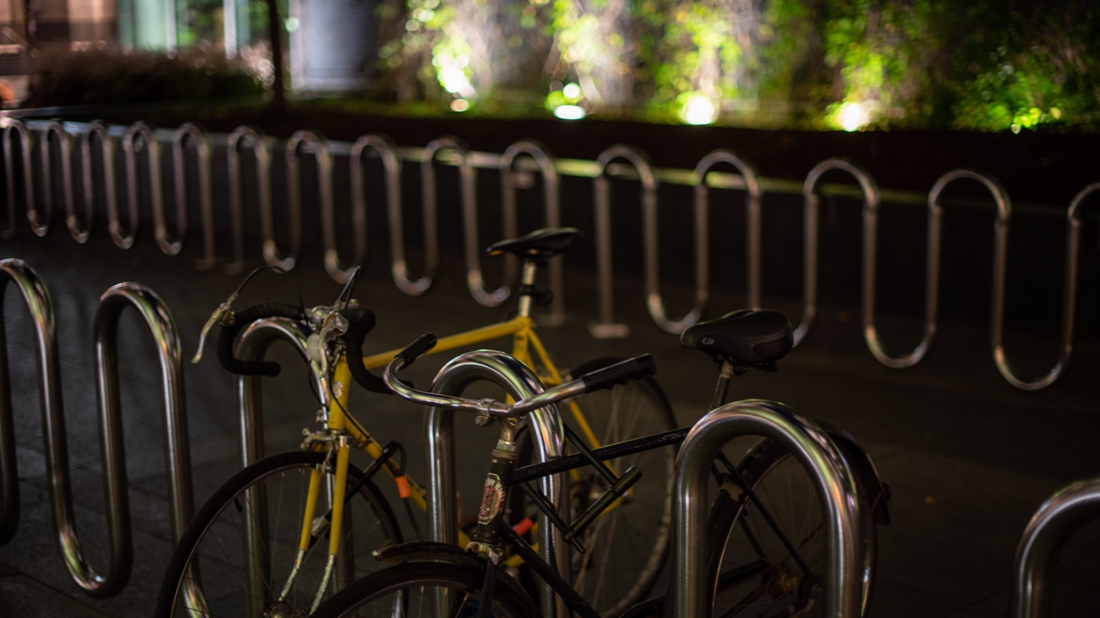 Abgeschlossenes Fahrrad an einem fast leeren Fahrradständer am Abend