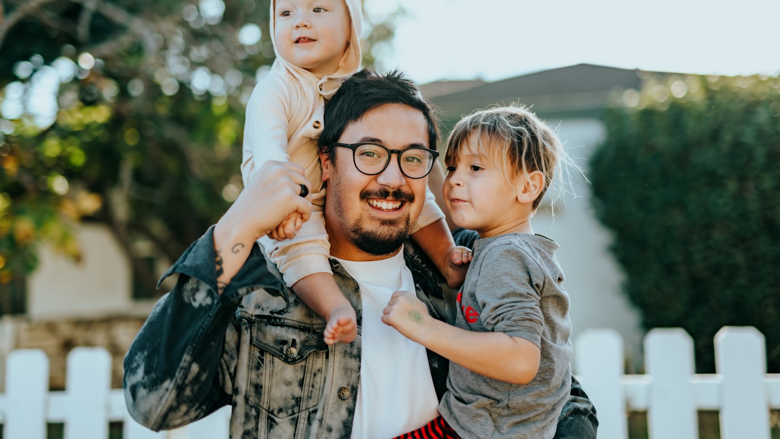 Vater trägt seine beiden Kinder – Sinnbild für die Familie, die von einem Einkommen lebt