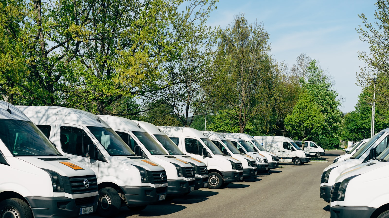 Reihe weißer Transporter eines Firmenfuhrparks