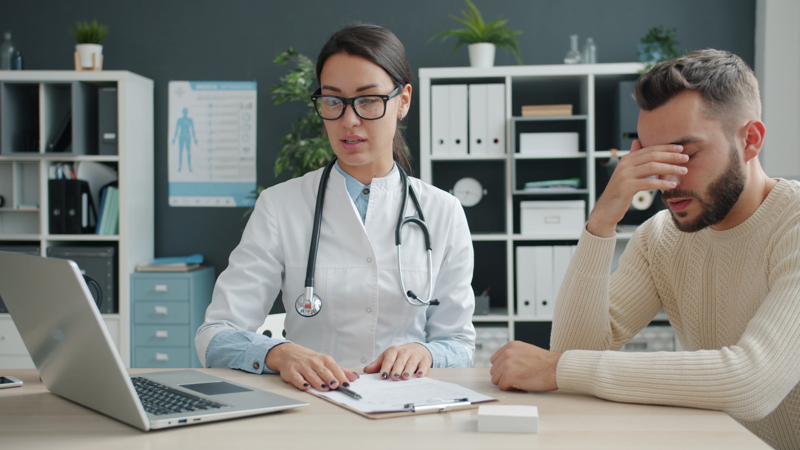 Ärztin im Gespräch mit einer Patientin am Schreibtisch einer Praxis