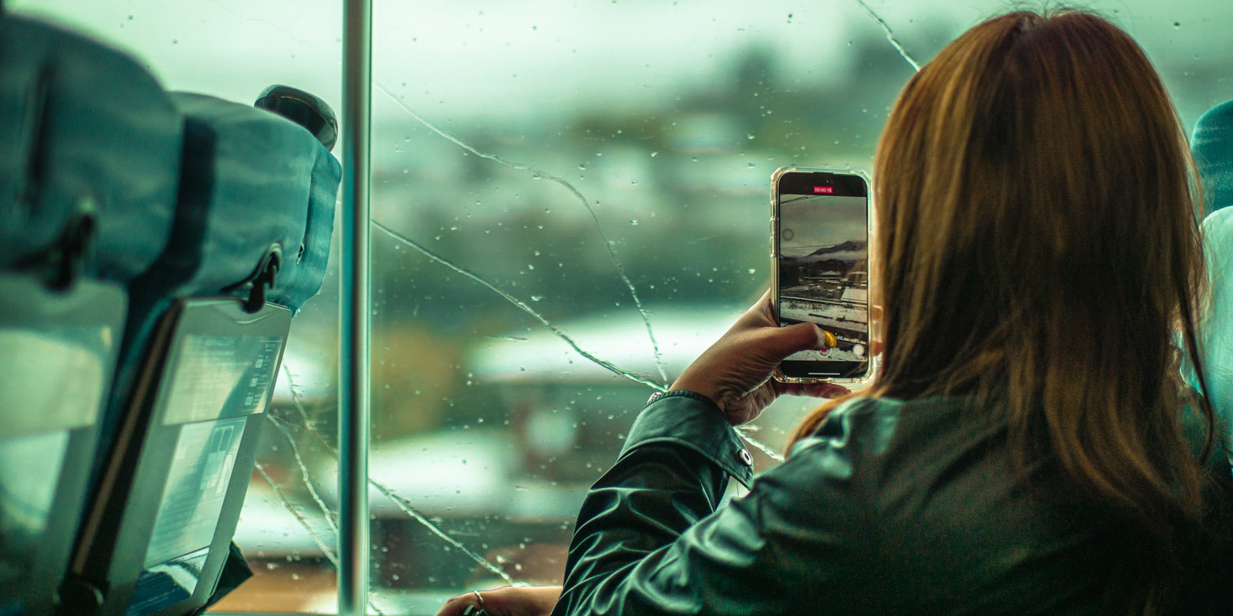 Frau fotografiert einen Glasschaden mit dem Smartphone, um den Schaden zu melden